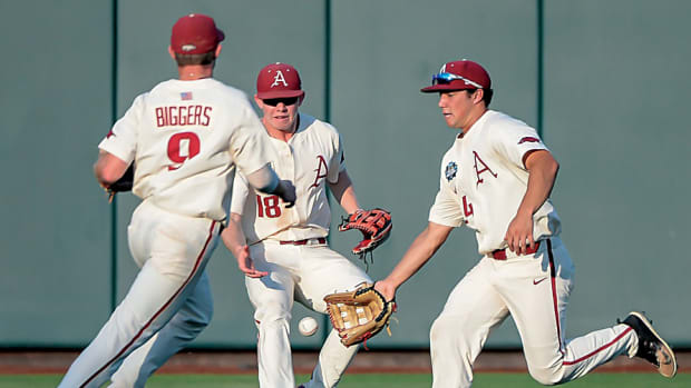 Arkansas Razorbacks shortstop Jax Biggers (9) and left fielder Heston Kjerstad (18) and center fielder Dominic Fletcher (24) converge on a ball in the game against the Oregon State Beavers in game 3 of the College World Series at TD Ameritrade Park. Arkansas dropped a similar pop-up in the previous game that would have clinched the championship.